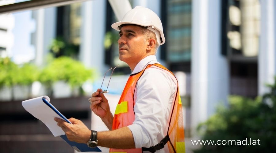Ingeniero FIDIC supervisando proyecto de infraestructura con documentos contractuales